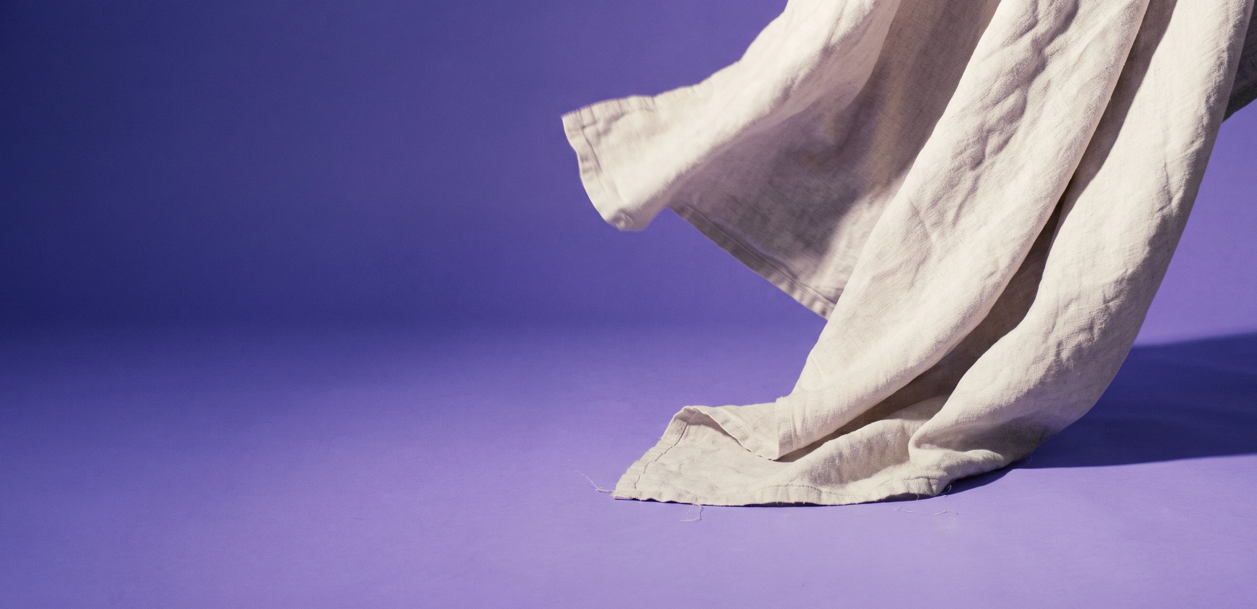 A bone-coloured linen sheet falling across iris seamless paper