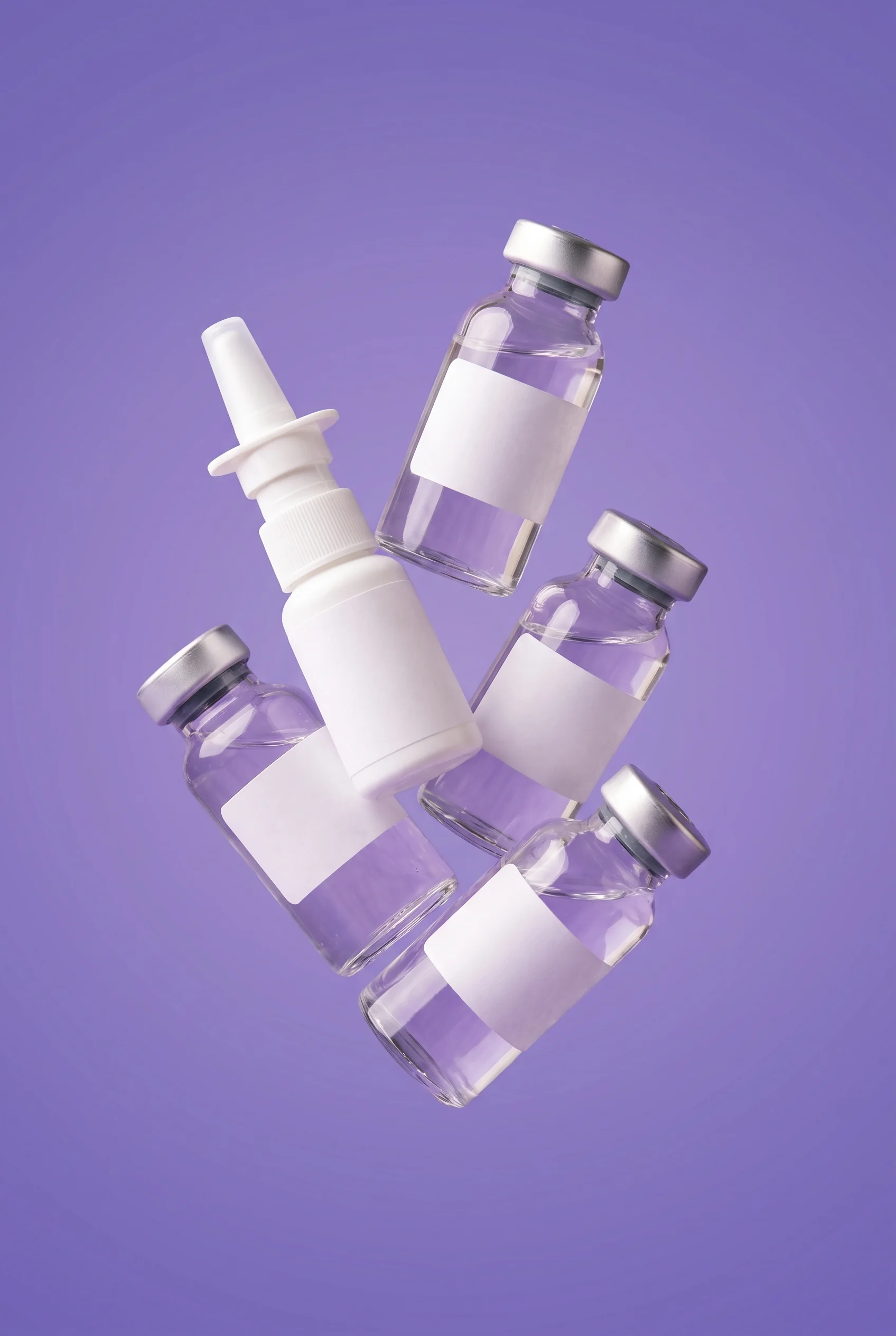 Four plain vials and one plain sprayer floating together on an iris ground