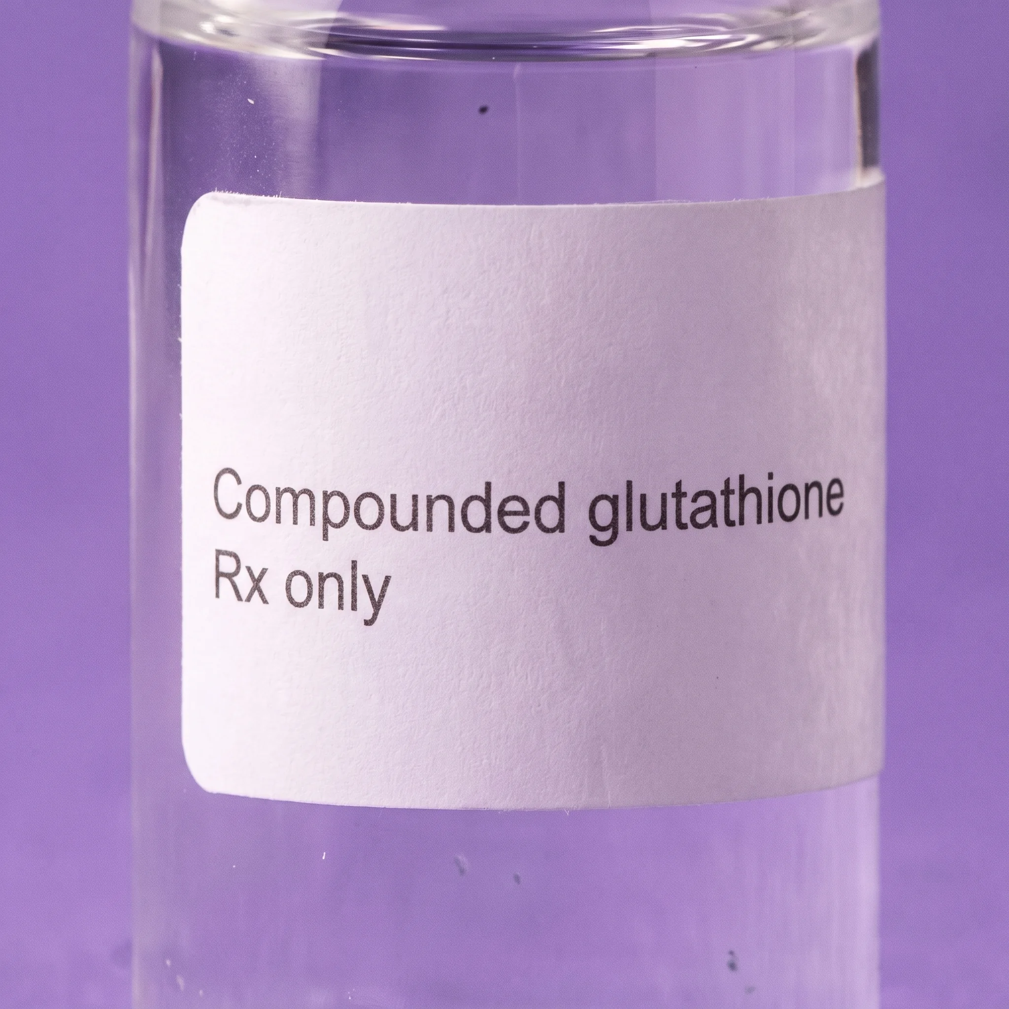 Macro detail of the plain white label, reading Compounded glutathione above Rx only