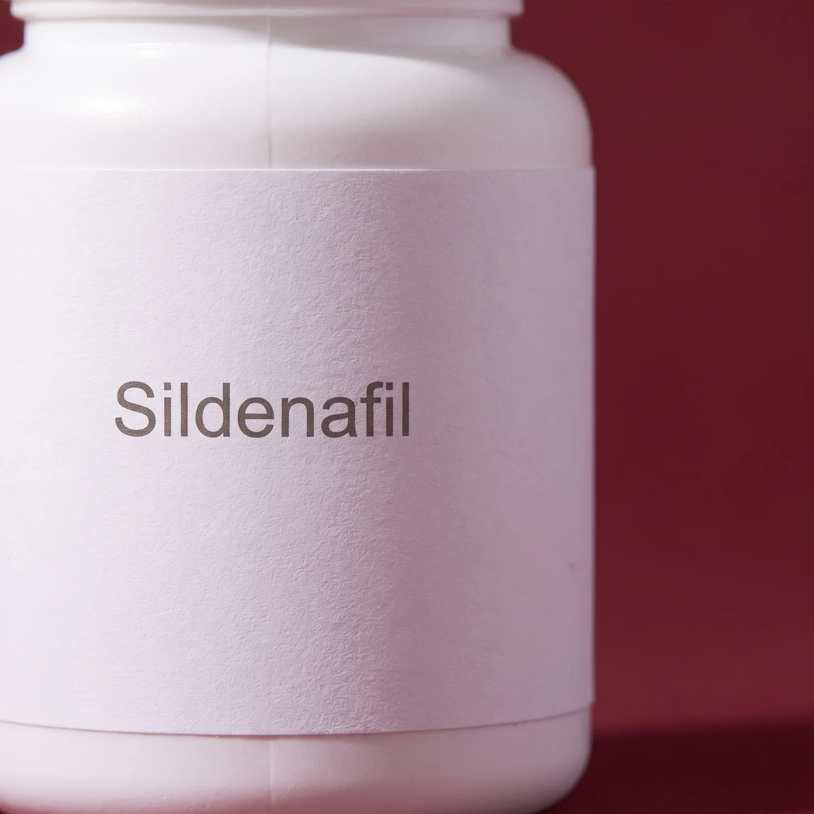 Macro of the plain white label on the bottle, reading Sildenafil