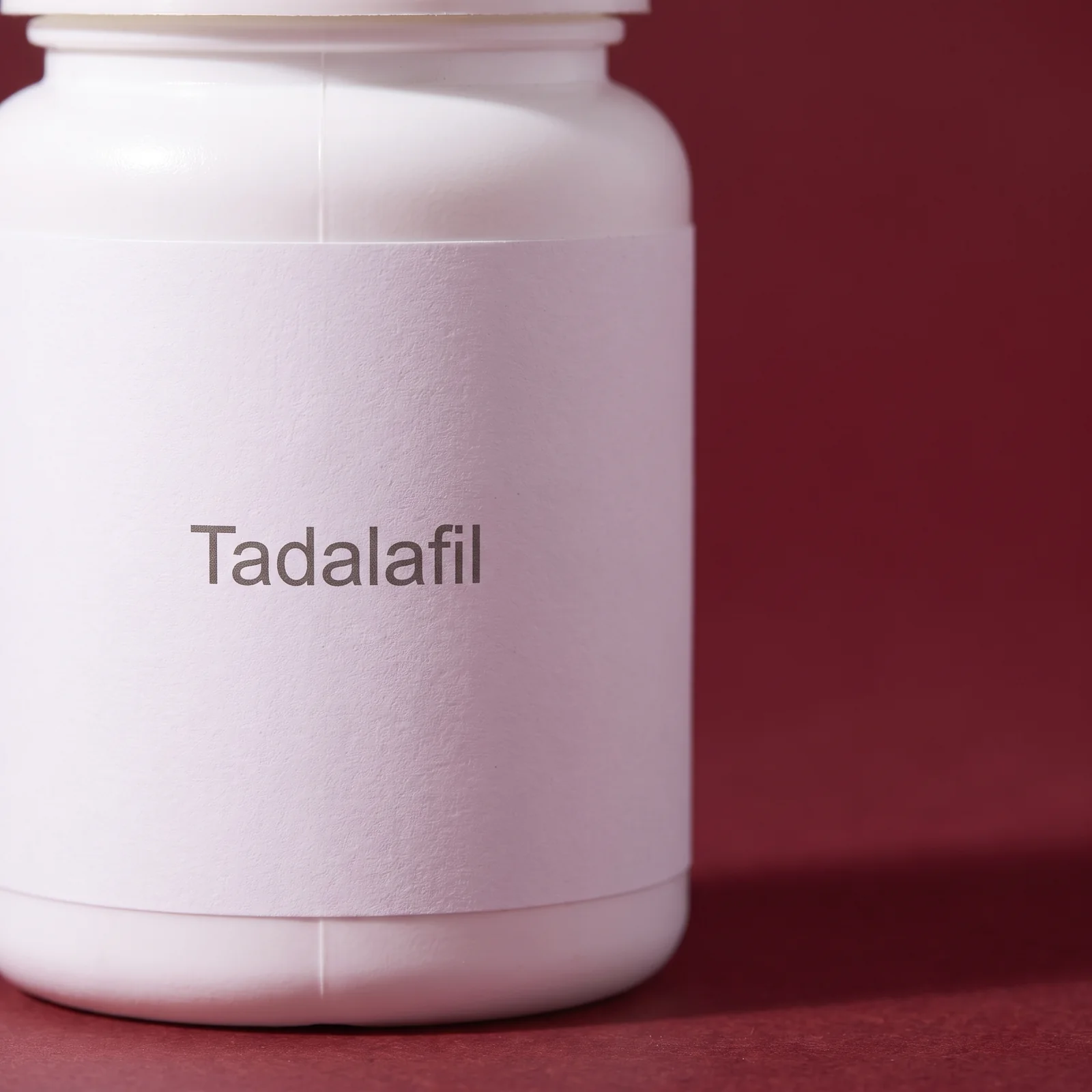 Macro of the plain white label on the bottle, reading Tadalafil